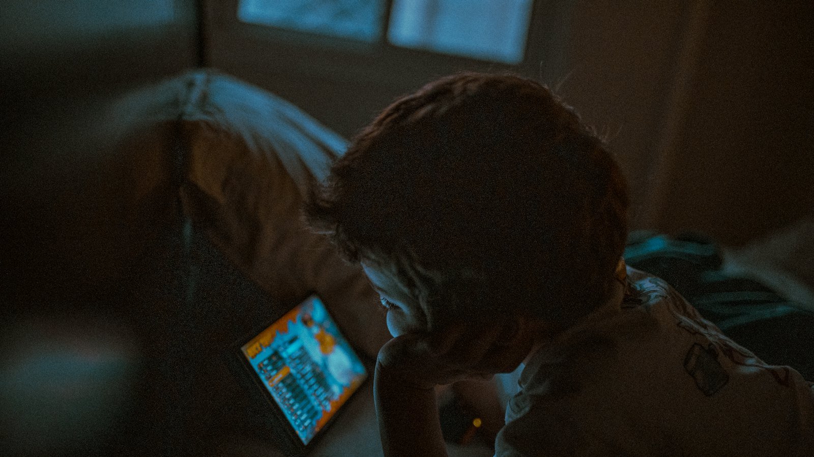 Ilmo mugdi ku jira oo eegaya tablet